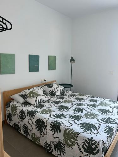 a bedroom with a bed with a green and white comforter at Casa Calafat in Calafat