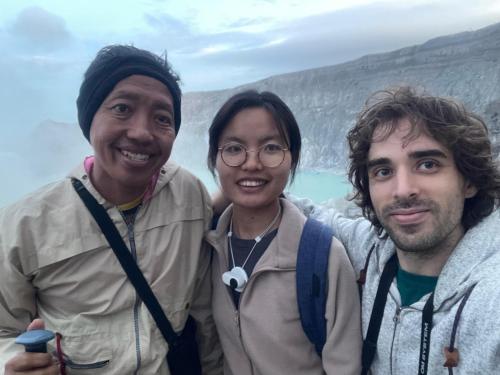 a group of three people standing in front of a mountain at Nio Homestay and Tour in Licin