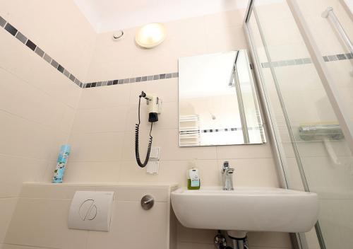 a bathroom with a sink and a phone on the wall at Ferienwohnung Inselzoo der WAG in Altenburg