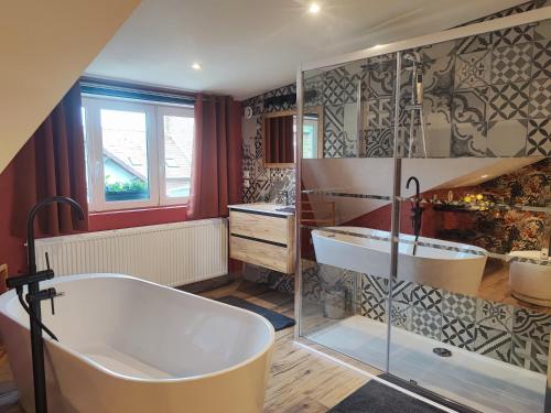 een grote badkamer met een bad en een wastafel bij Loft envie deux in Rivery