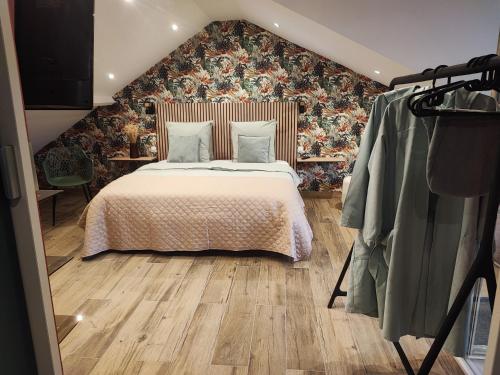 een slaapkamer met een bed met een bloemenmuur bij Loft envie deux in Rivery