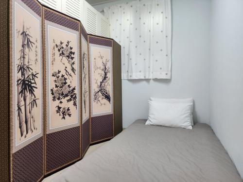 a bed in a room with paintings on the wall at Rosemary in Seoul