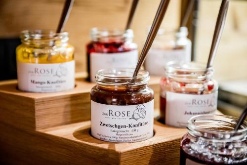 um grupo de potes de geleia em uma prateleira de madeira em Hotel zur Rose em Eglofs