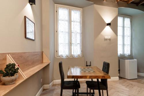 a dining room with a wooden table and chairs at Vertical Garden Studio by Quokka 360 - Modern studio in Como Downtown in Como