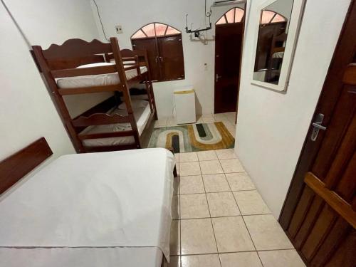 a small room with a bunk bed and a door at Suite aconchegante do Tapana in Belém
