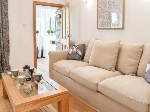 a living room with a couch and a table at Thornton Cottage in Grizebeck