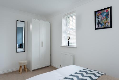 a white bedroom with a bed and a window at Peaceful, Perfect for Work, Leisure, Free Parking in Bletchley