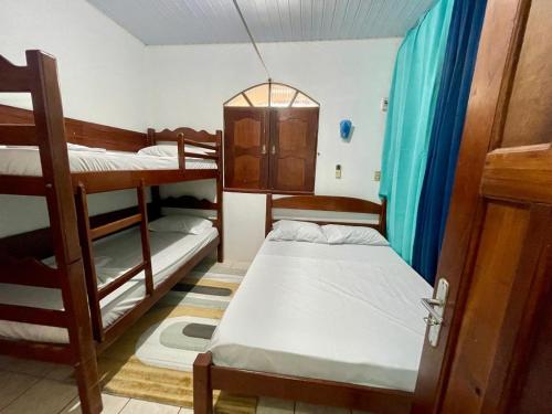 a room with three bunk beds in a room at Suite aconchegante do Tapana in Belém