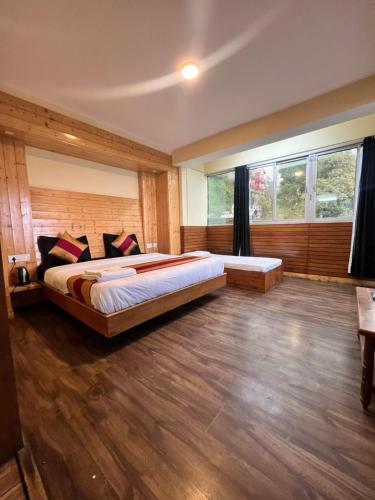 a bedroom with a large bed and a large window at GS COTTAGE BED and BREAKFAST walking distance from Mall Road in Shimla