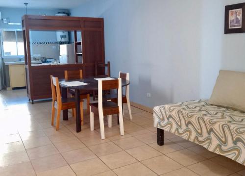 a dining room with a table and chairs and a couch at Apart Hotel Bell in San Fernando del Valle de Catamarca
