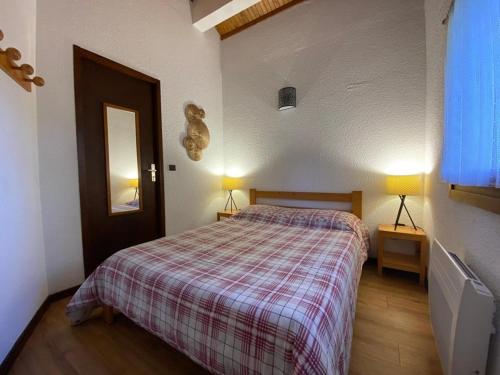 a bedroom with a bed with a plaid blanket and two lamps at Appartement 5 personnes près des pistes avec vue magnifique - FR-1-733-172 in Crest-Voland