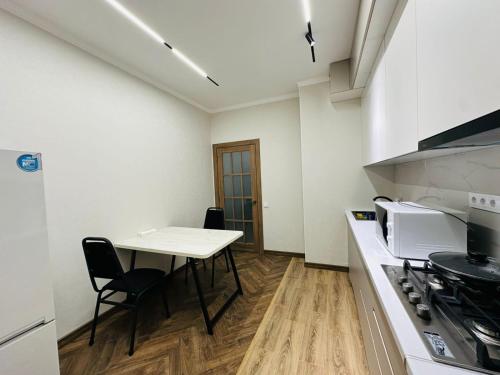 a small kitchen with a table and a stove at 1 комнатная квартира в центре Конаева in Kapchagay