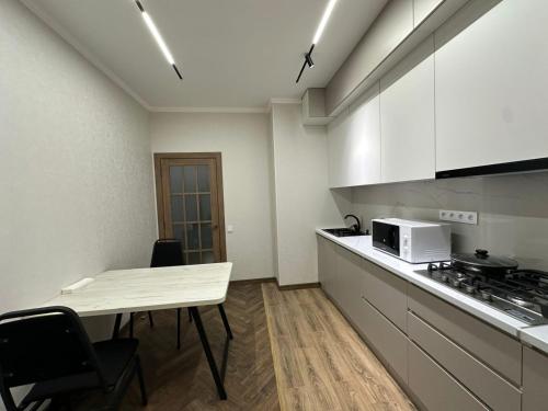 a small kitchen with a table and a microwave at 1 комнатная квартира в центре Конаева in Kapchagay