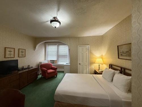 a hotel room with a bed and a red chair at Windsor Inn Hotel in Washington, D.C.