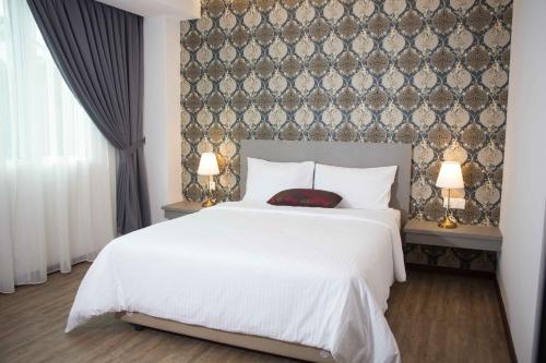 فندق كلاسيك في سيبانغ: غرفة نوم بسرير ابيض ومصباحين