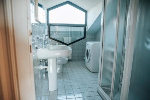a bathroom with a sink and a toilet and a window at Cascina Bringin in Mondovì