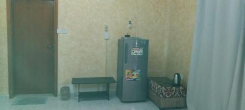 a small refrigerator in a room with a table at HOUSE IN AL AIN in Al Ain