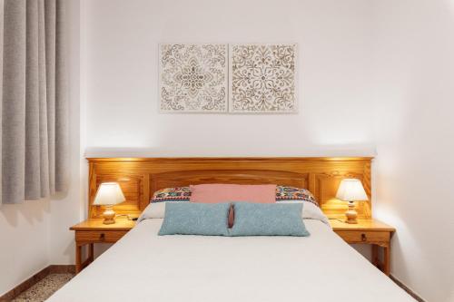 Un dormitorio con una cama blanca con dos lámparas. en CHL Armonía, see side views in Puerto Naos, en Puerto Naos