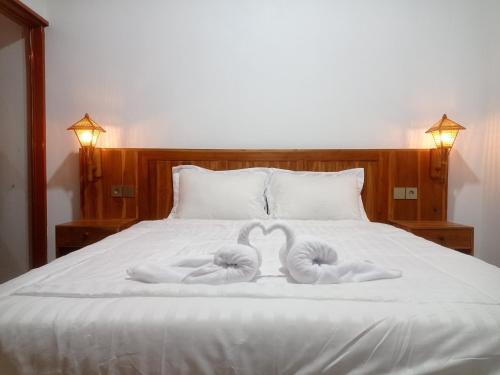 dos toallas en forma de corazones en una cama en Rice Terrace Bungalows, en Tetebatu