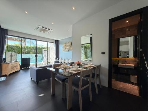 a dining room with a table and a couch at 2 Bedroom Pool Villa Chalong in Chalong