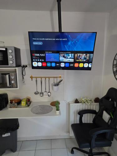 TV colgada en la pared de una cocina en Studio Antigone centre ville, en Montpellier