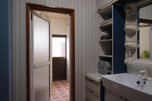 a bathroom with a shower door and a sink at Shimanto Suite By Hideaway 