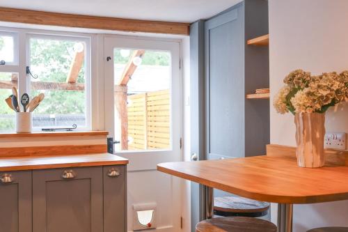a kitchen with a wooden table and a window at Quaint Cottage by the Castle in Kenilworth