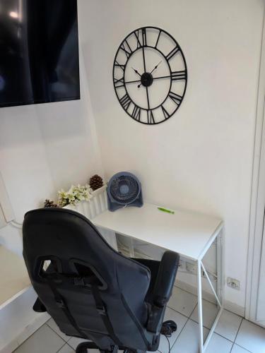 escritorio con silla y reloj en la pared en Studio Antigone centre ville, en Montpellier