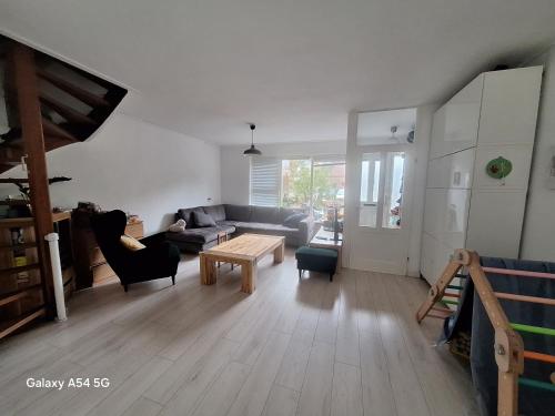 una sala de estar con un sofá y una mesa en Large family house in Tanthof, Delft, en Delft