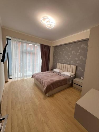 a bedroom with a bed and a large window at Alvina complex in Tsaghkadzor