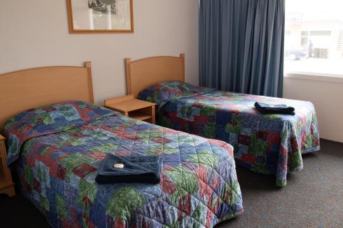 ein Hotelzimmer mit zwei Betten und einer Tasche auf dem Bett in der Unterkunft Sportsmans Arms Hotel Motel Deniliquin in Deniliquin