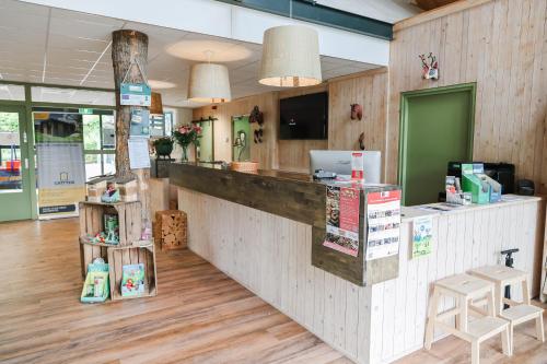 a fast food restaurant with a counter and chairs at Chalet 4 persoons in Hoogersmilde