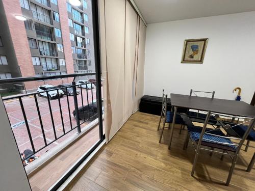 Habitación con mesa y balcón con vistas. en Moderno apartamento frente a viva mall, en Tunja