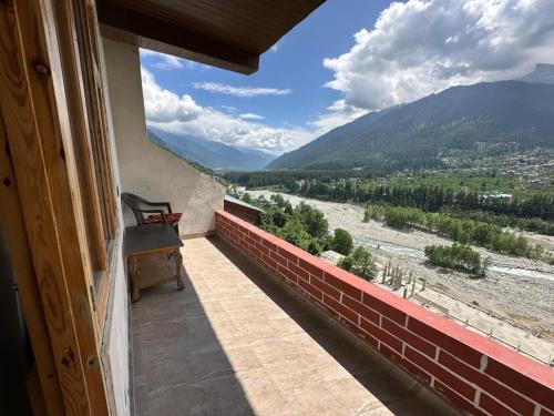 a balcony with a view of a river and mountains at River Bed in Vashisht