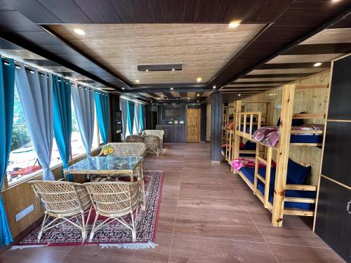a room with bunk beds and a table and chairs at River Bed in Vashisht