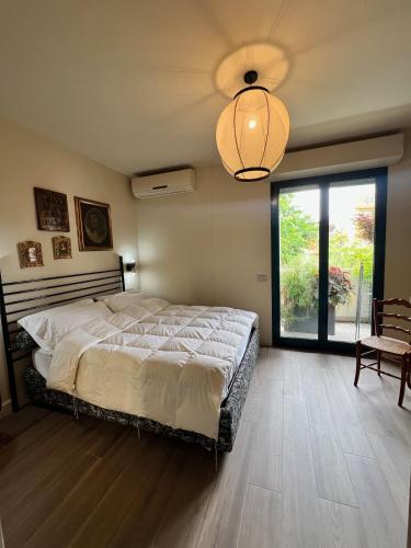 a bedroom with a large bed and a large window at 5 Viale Fano Apartment in Rimini