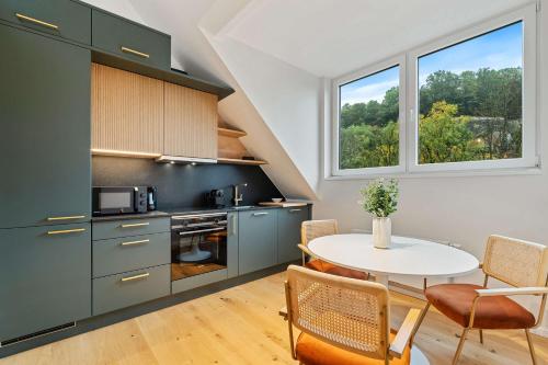 a kitchen with a table and chairs and a window at Charming Apartment in Historic Pafendall in Luxembourg
