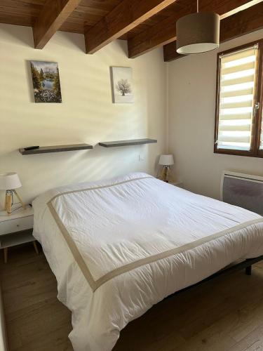 ein Schlafzimmer mit einem großen weißen Bett und einem Fenster in der Unterkunft Duplex with spectacular mountain views for 8 in Porté-Puymorens