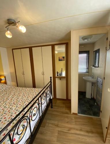 a bedroom with a bed and a bathroom with a sink at Sea veiw in Kinmel Bay