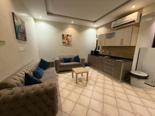 ein Wohnzimmer mit Sofa und Tisch in der Unterkunft ليالي رهيف للشقق المخدومه in Abha