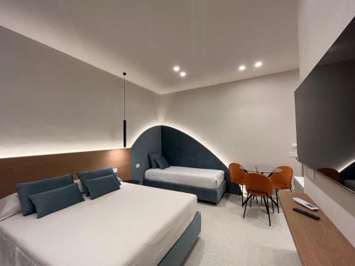 a bedroom with a bed and a table and chairs at Angilè Rooms in Agrigento