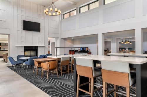 a lobby with a bar and tables and chairs at Homewood Suites by Hilton Newtown - Langhorne, PA in Newtown