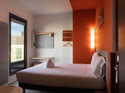 a hotel room with a bed and a window at Ibis Budget Madrid Centro Lavapies in Madrid
