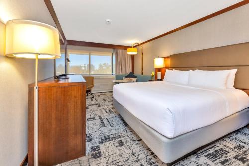 a bedroom with a large white bed and a lamp at Crowne Plaza Hotel Foster City-San Mateo by IHG in Foster City