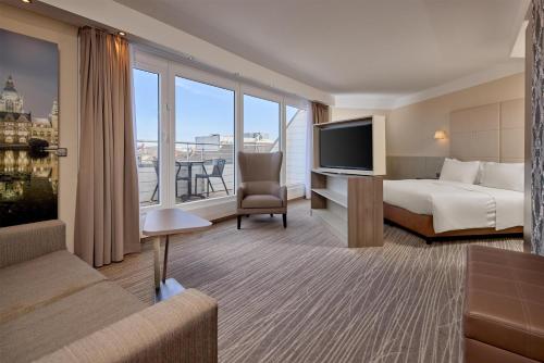 a hotel room with a bed and a flat screen tv at DoubleTree by Hilton Hannover Schweizerhof in Hannover