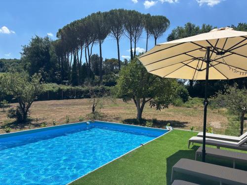 a swimming pool with an umbrella and two chairs at Villa with Garden near Rome for Groups & Families in Orte