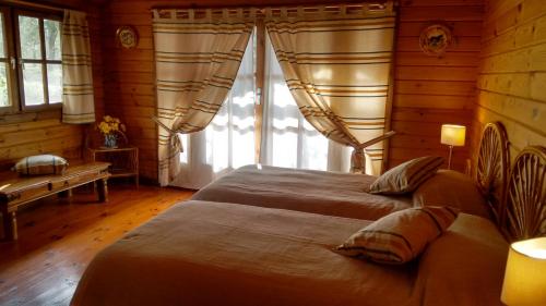 a bedroom with two beds and a large window at Finca La Piedra Holidays in Alora