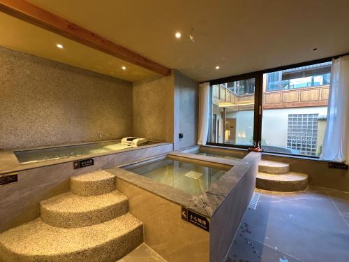 a room with a swimming pool and some stairs at Hotel NANDANA in Diannan