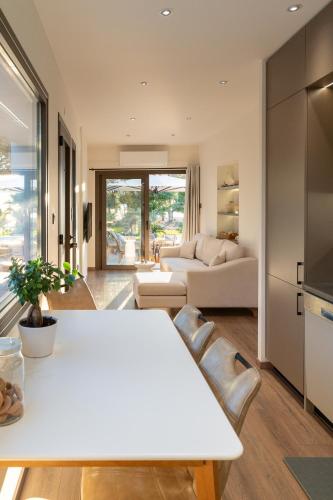a living room with a white table and a couch at Petrochori Beach House in Voidokilia