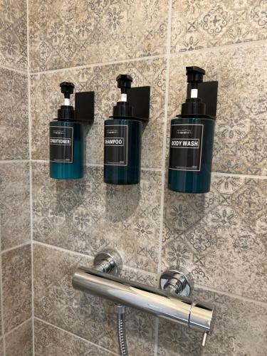 Un par de botellas de odorantes en la pared del baño. en Casa Salcheto, en Montepulciano